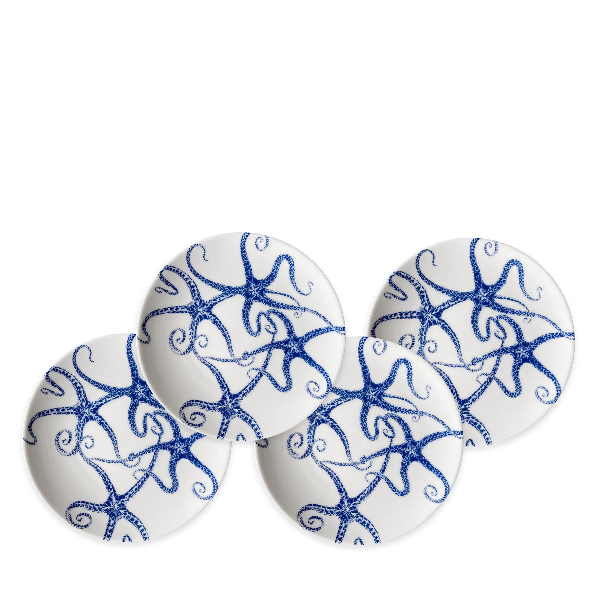 Four white ceramic starfish plates featuring blue starfish designs arranged in a circular pattern, crafted from lead-free porcelain and heirloom-quality dinnerware, called the Starfish Small Plates by Caskata Artisanal Home.