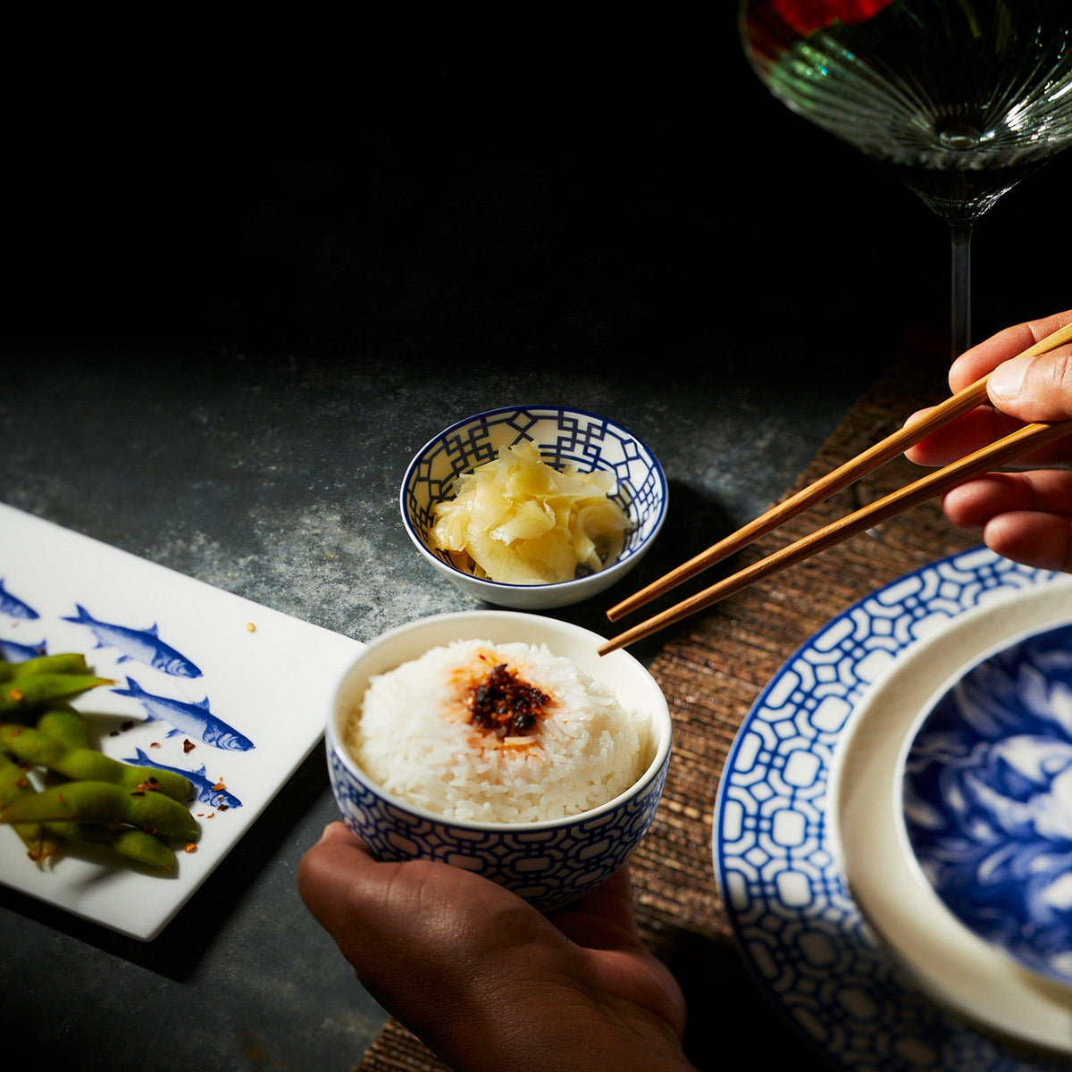 Someone holding a Newport Snack Bowl filled with rice. Premium, blue and white porcelain small bowl from Caskata.